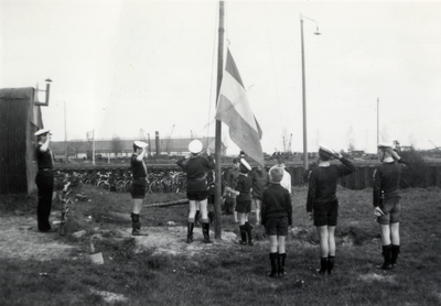 811894 Afbeelding van het hijsen van de vlag tijdens een installatieplechtigheid bij de Wilhelminagroep zeeverkenners ...
